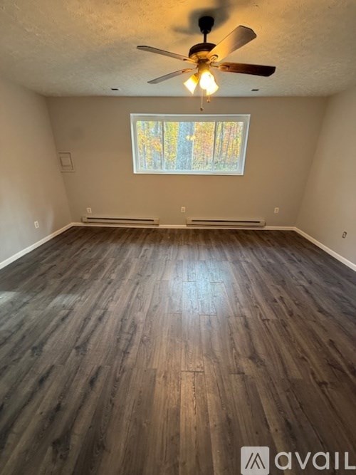 A room with wooden flooring and a ceiling fan.