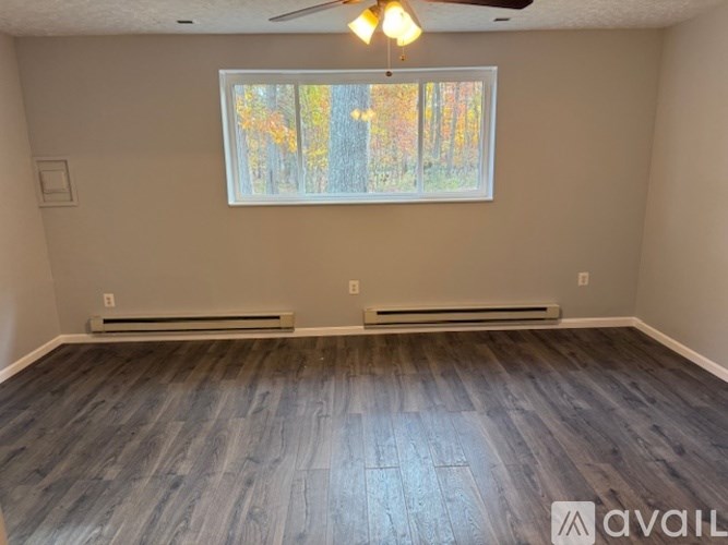 A room with a window and a ceiling fan.