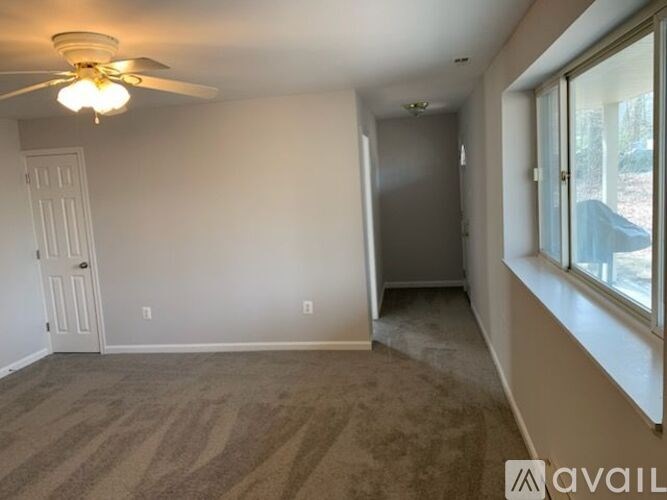 A room with a ceiling fan and carpeted floor.