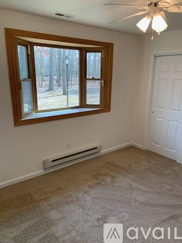 A room with a window and a ceiling fan.