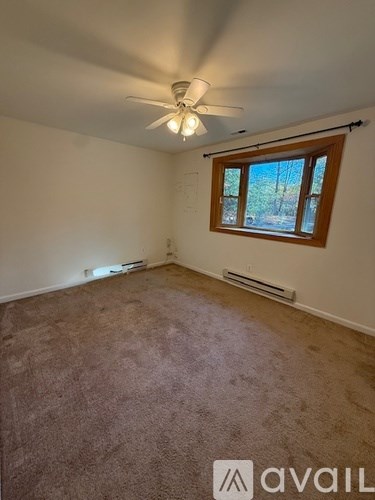A room with a ceiling fan and a window.
