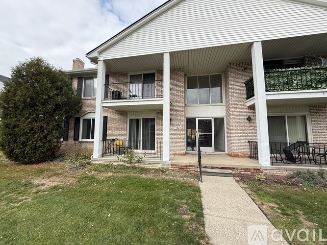 A two-story brick apartment building with a balcony on the second floor.