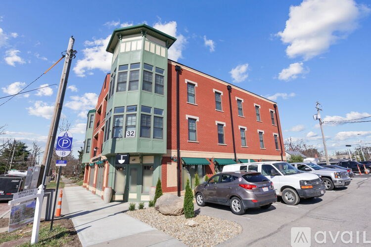 A parking sign is on a pole next to a sidewalk.