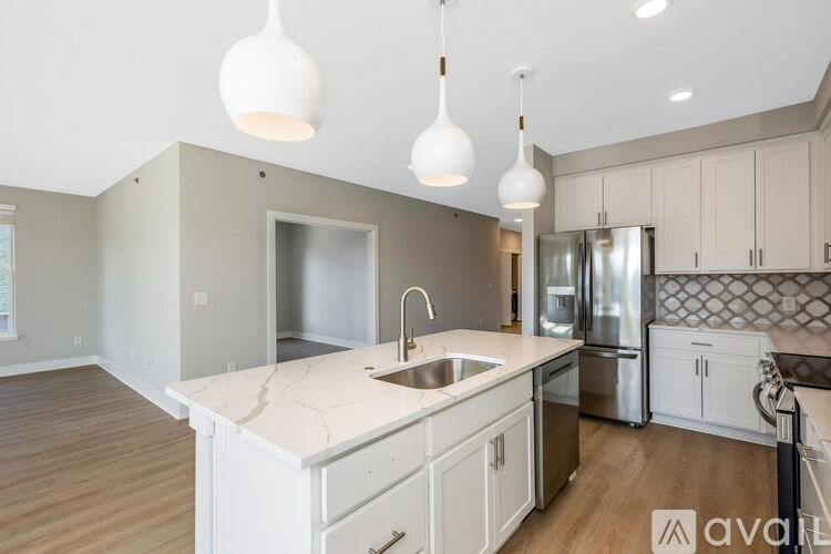 A kitchen with a marble countertop and stainless steel appliances.