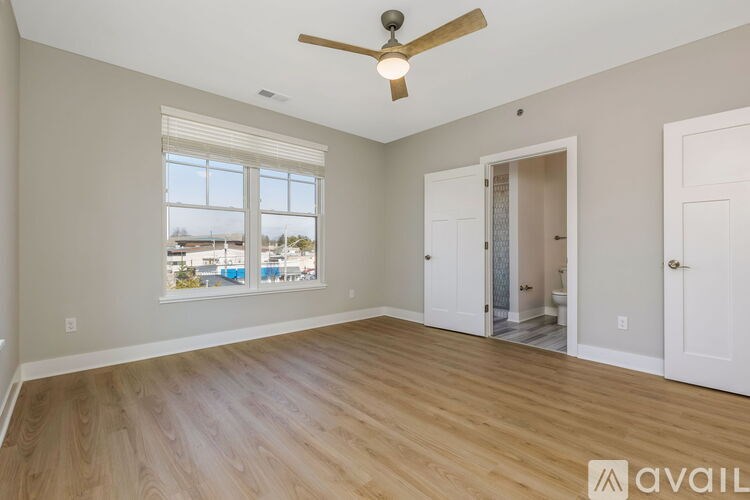 A room with a ceiling fan and wooden flooring.