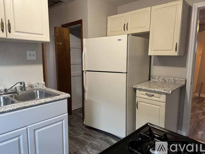 A kitchen with a white fridge and a black stove top.