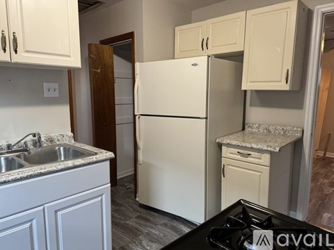 A kitchen with a white fridge and a black stove top.