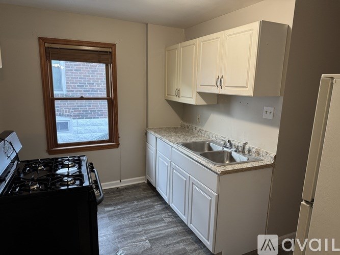 A kitchen with a black stove top and white cabinets.