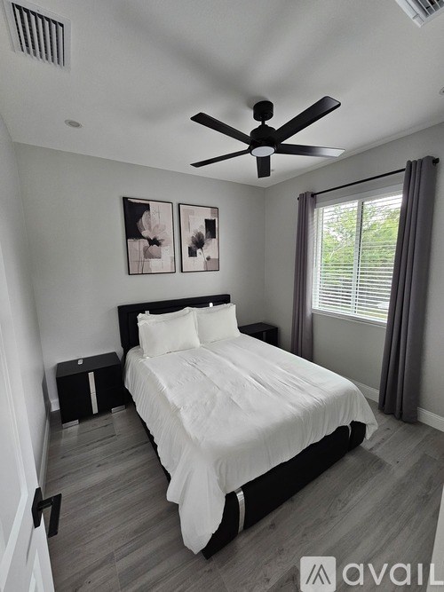 A bedroom with a large bed and a ceiling fan.