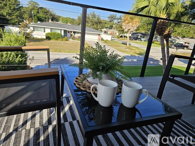Two white mugs on a table with a plant in between them.