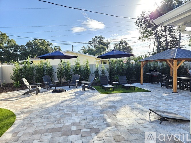 A patio with a table and chairs under umbrellas.