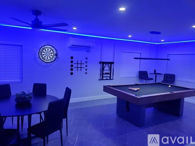 A room with a pool table and a dartboard on the wall.