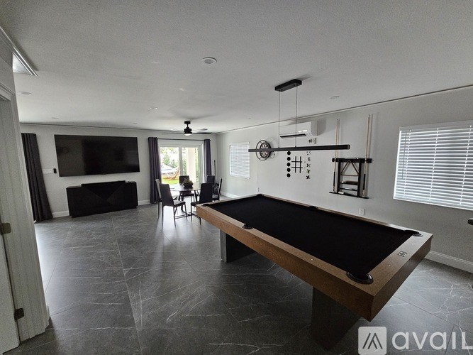 A room with a pool table and a television.