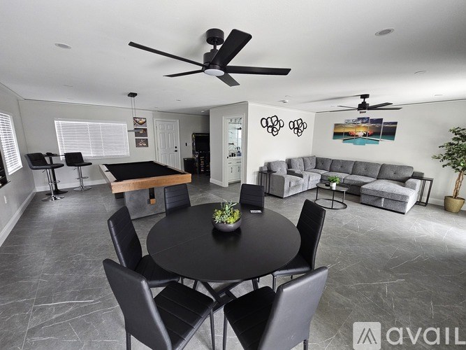 A modern living room with a black table and chairs.