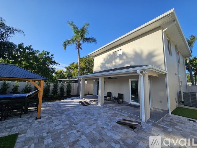 A house with a patio and a palm tree in front.