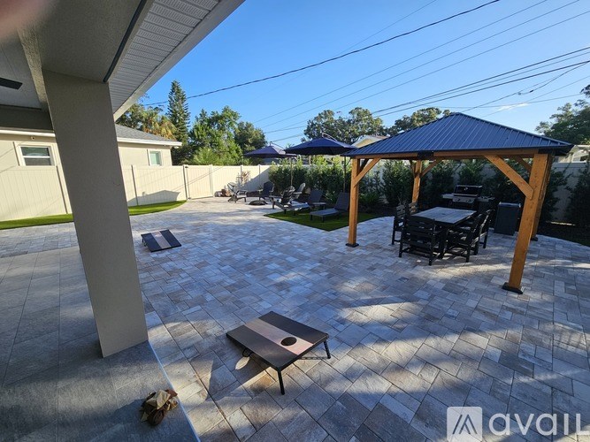 A patio with a table and chairs under a gazebo.