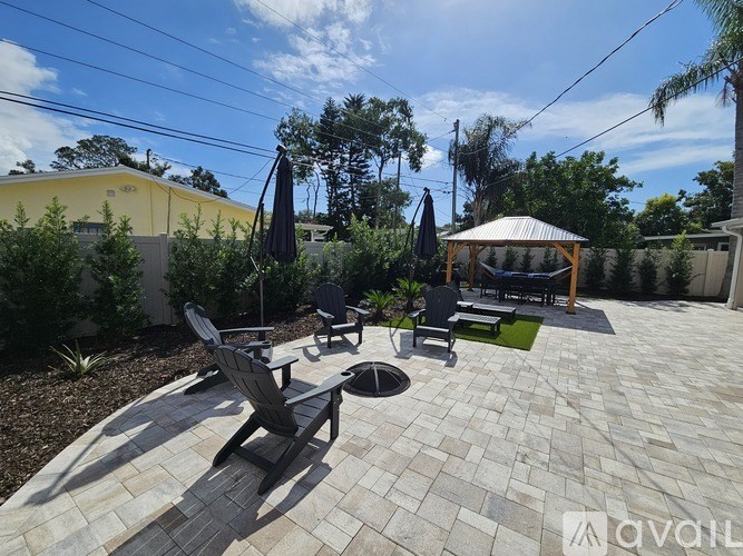 A patio with a table and chairs and a gazebo.