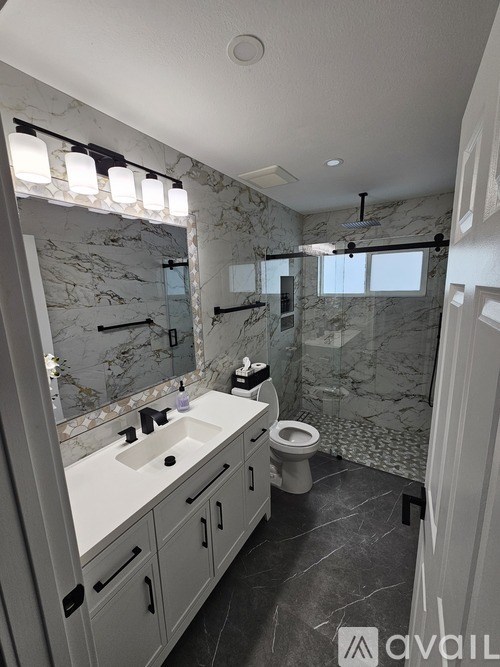 A bathroom with a marble wall and a toilet.