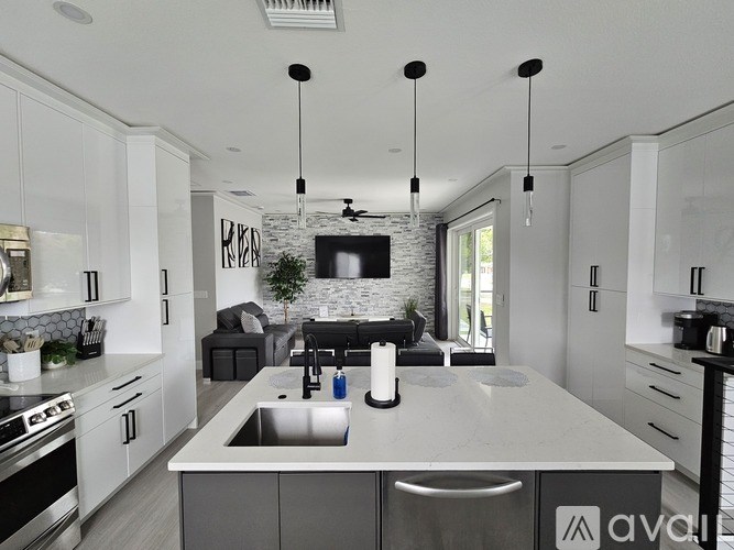 A modern kitchen with a large island and a stone backsplash.