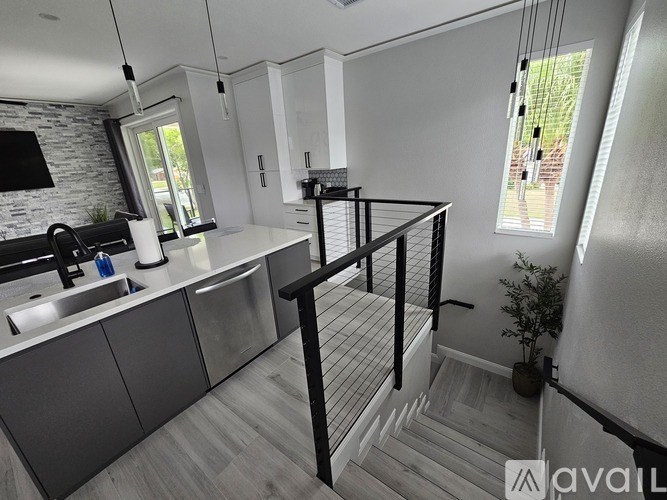 A modern kitchen with a white countertop and a black stool.