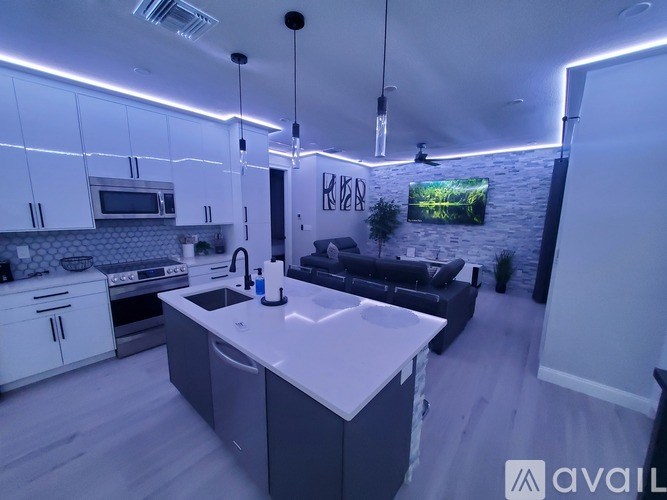 A modern kitchen with a white countertop and a black couch.