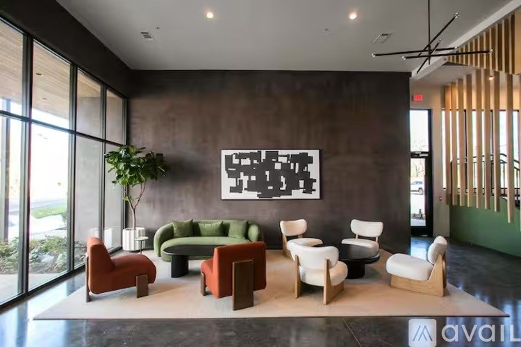 A room with a green couch and a painting on the wall.