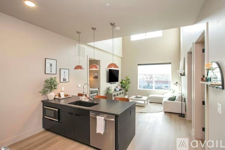 A modern kitchen with a black countertop and stainless steel appliances.