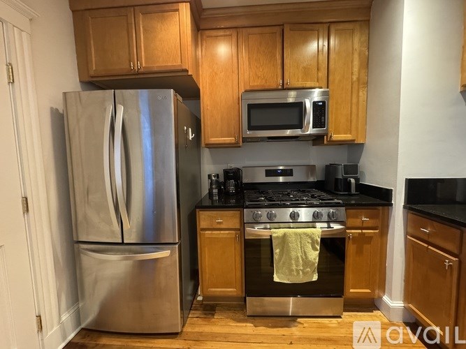 A kitchen with wooden cabinets and a stainless steel refrigerator.
