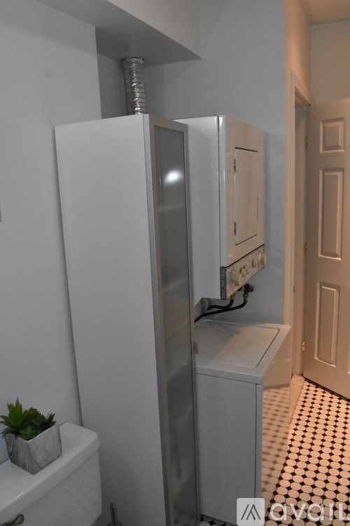 A white refrigerator in a room with a tiled floor.
