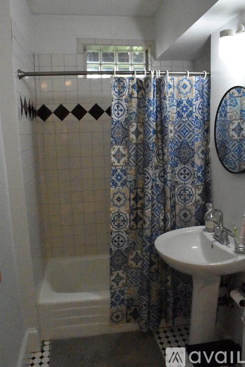 A bathroom with a white sink and a blue and white shower curtain.