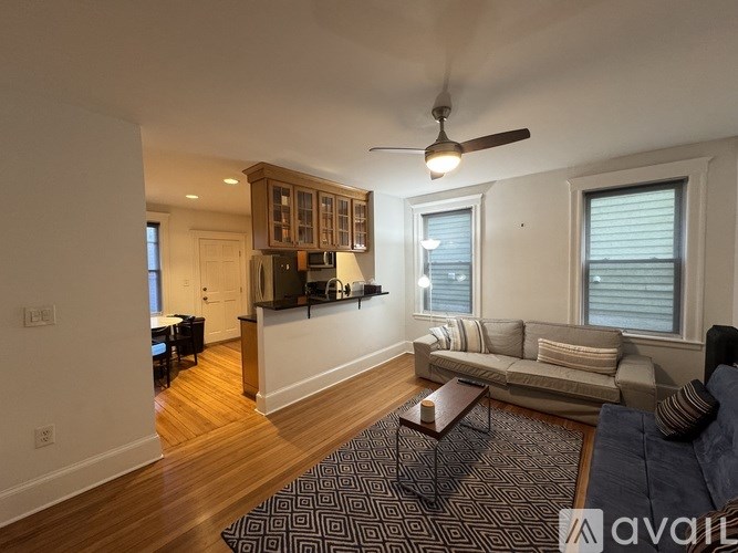 A living room with a couch, a coffee table, and a ceiling fan.