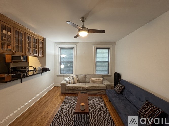 A living room with a couch, a coffee table, and a ceiling fan.