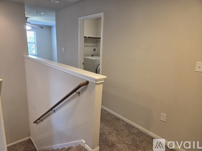 A room with a staircase and a doorway leading to another room.