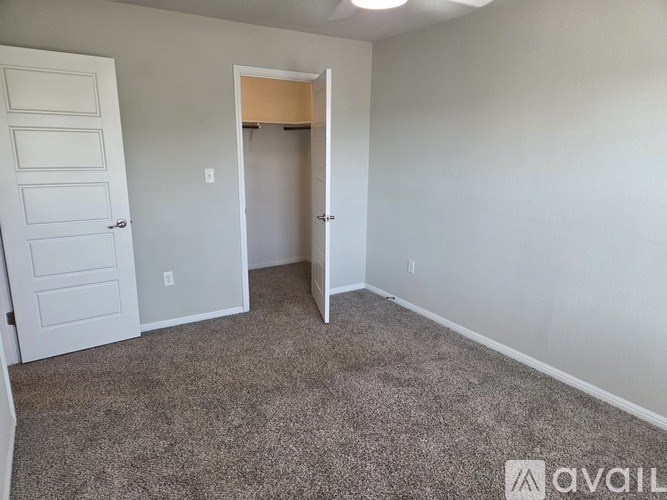 A room with a carpeted floor and a doorway leading to another room.