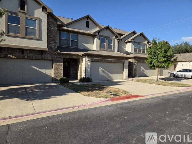 A row of houses with a car parked in the driveway.