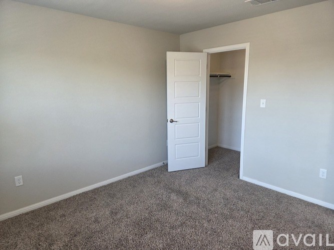 A room with a carpeted floor and a white door.