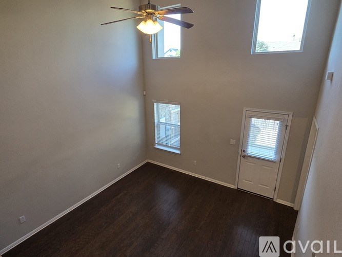 A room with a ceiling fan and a window with blinds.