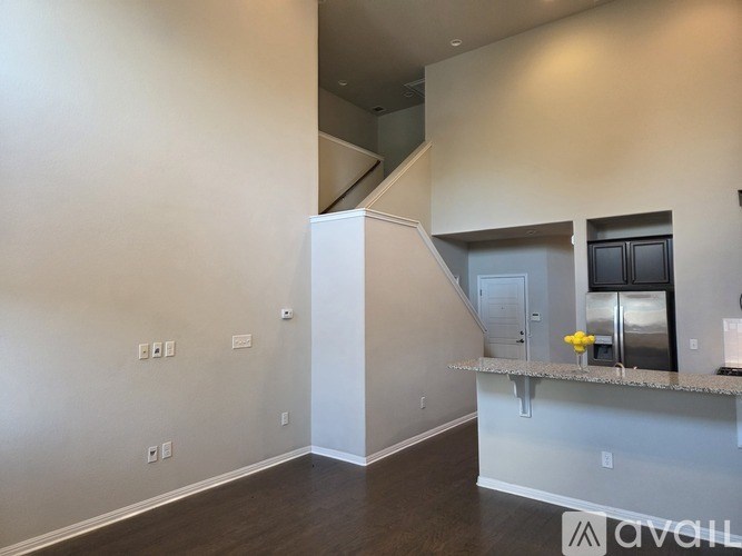 A room with a staircase and a counter in the foreground.