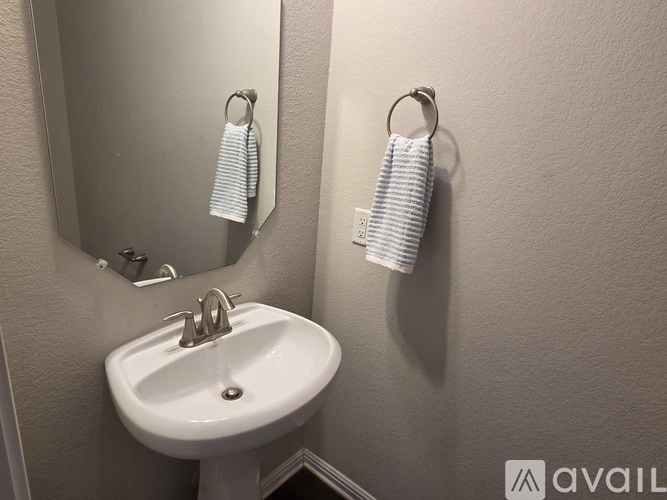 A bathroom with a white sink and towel rack.