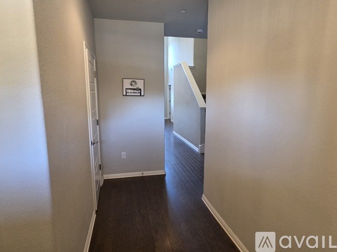 A hallway with a sign on the wall and a door at the end.