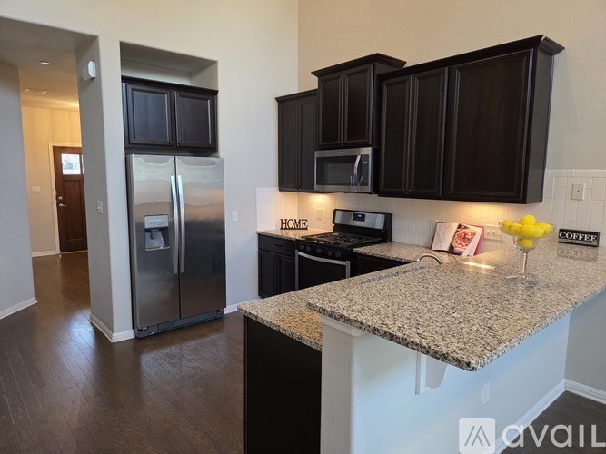 A kitchen with a granite counter top and a refrigerator.