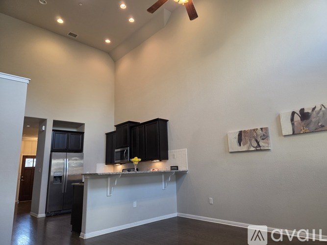 A kitchen area with a refrigerator, microwave, and a countertop.