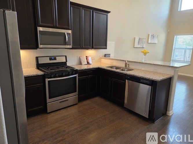 A kitchen with dark brown cabinets and stainless steel appliances.