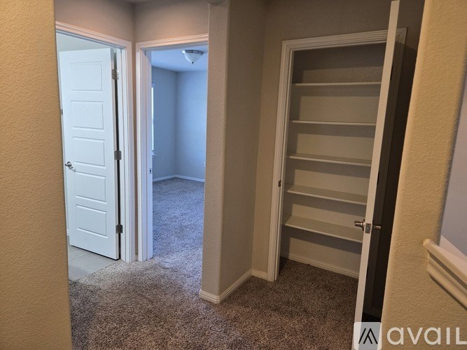 A room with a white door and a white closet with shelves.