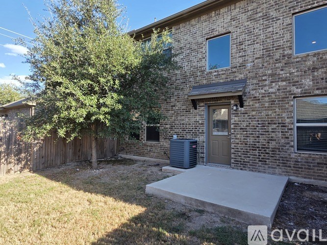 A brick house with a tree and a brown door.