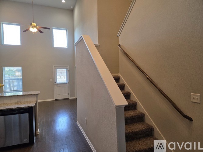 A staircase with a carpeted runner and wooden steps leads up to a second floor.
