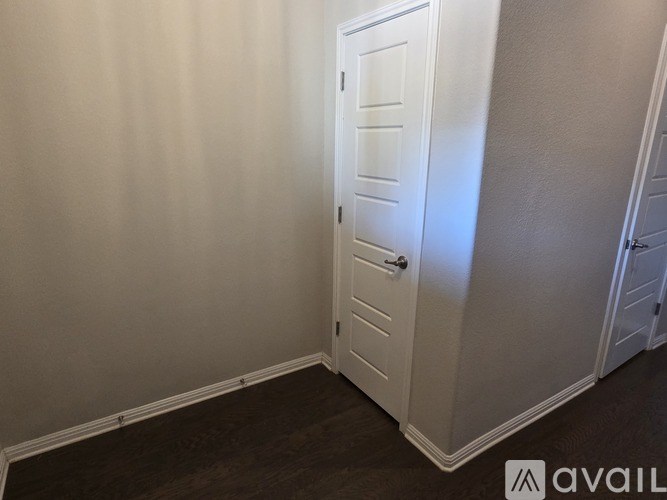 A white door in a room with a wooden floor.