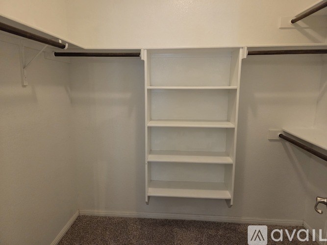 A white shelving unit in a room with a patterned carpet.