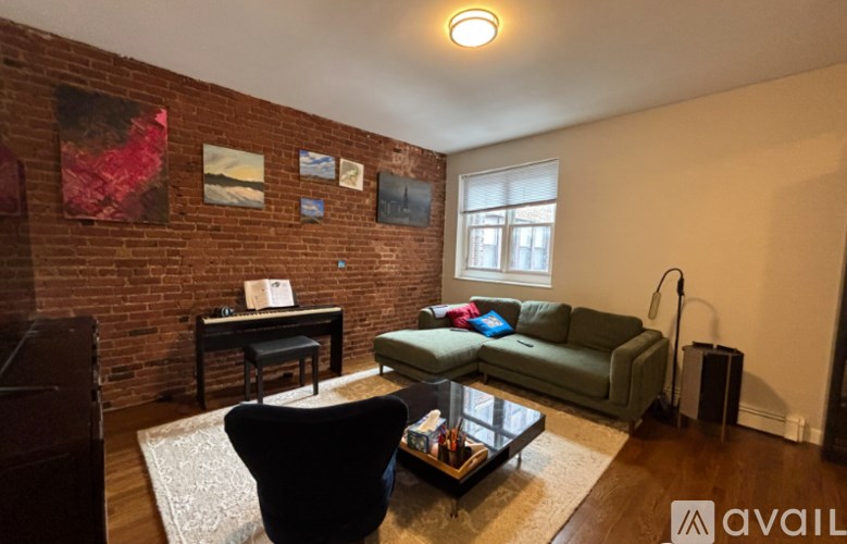A living room with a green couch and a black chair.