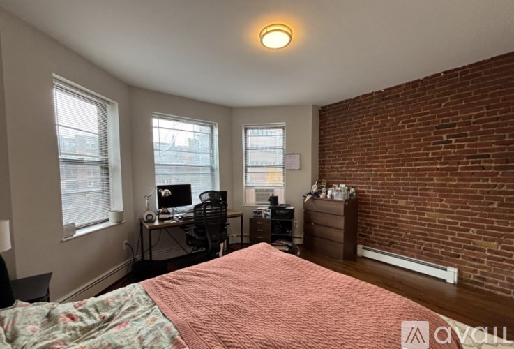 A bedroom with a bed, desk, and chair.